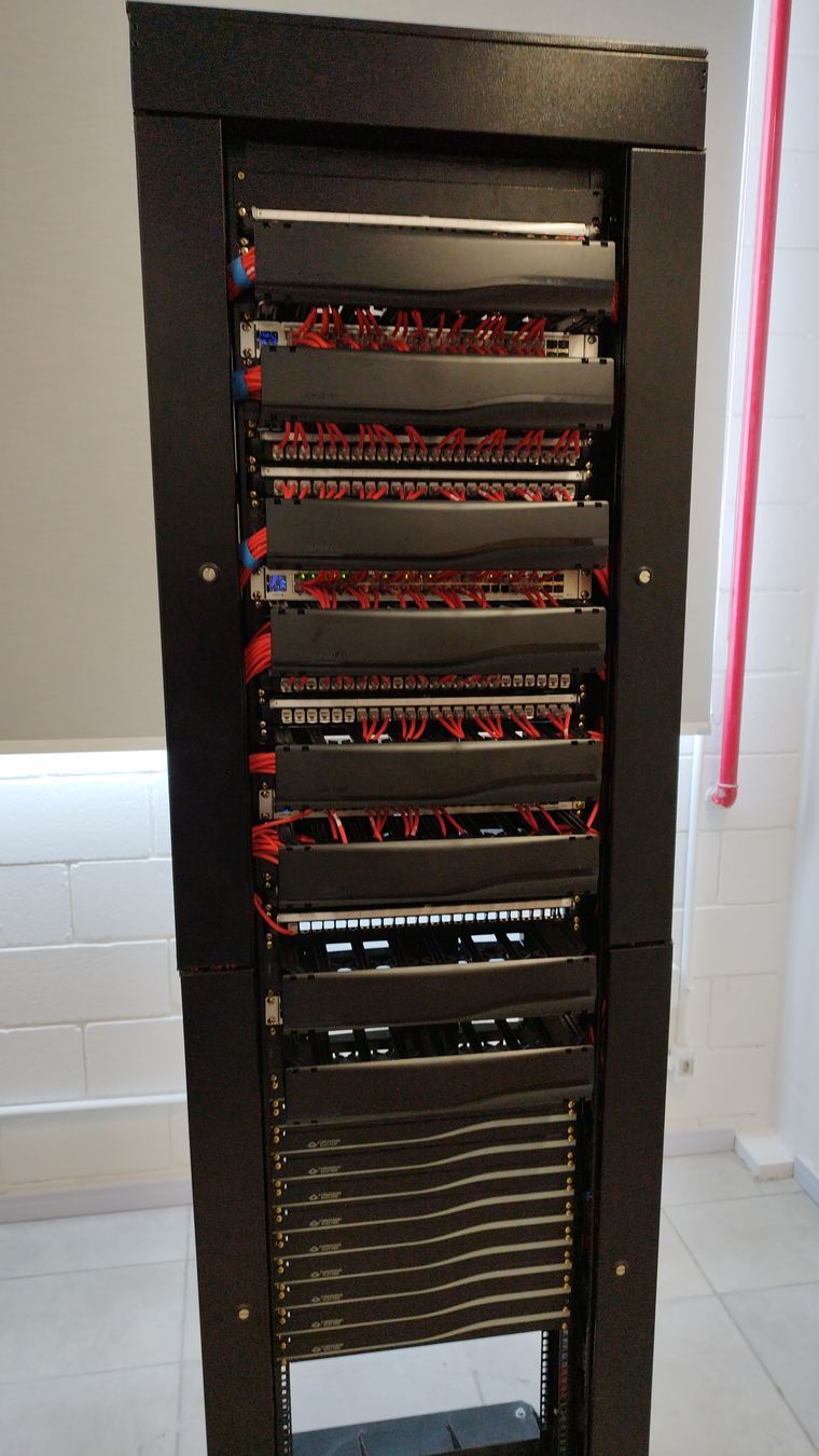 Rack de telecomunicações com switches e patch panels organizados, cabeamento Cat6A identificado